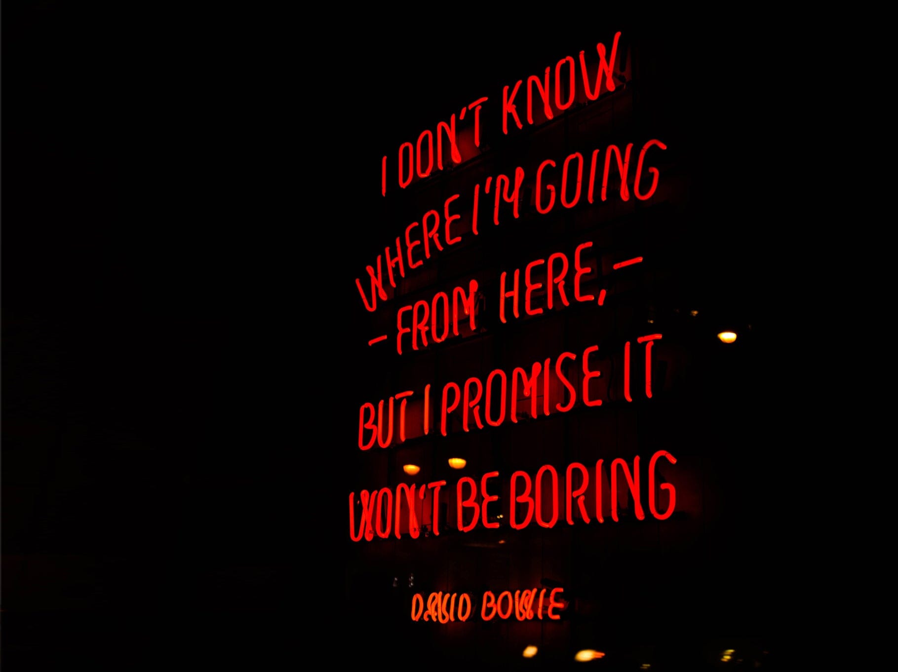 Red neon sign that reads "I don't know where I'm going from here, but I promise it won't be boring. David Bowie"