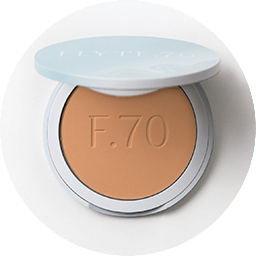 Compact of finishing powder in warm apricot and beige hue